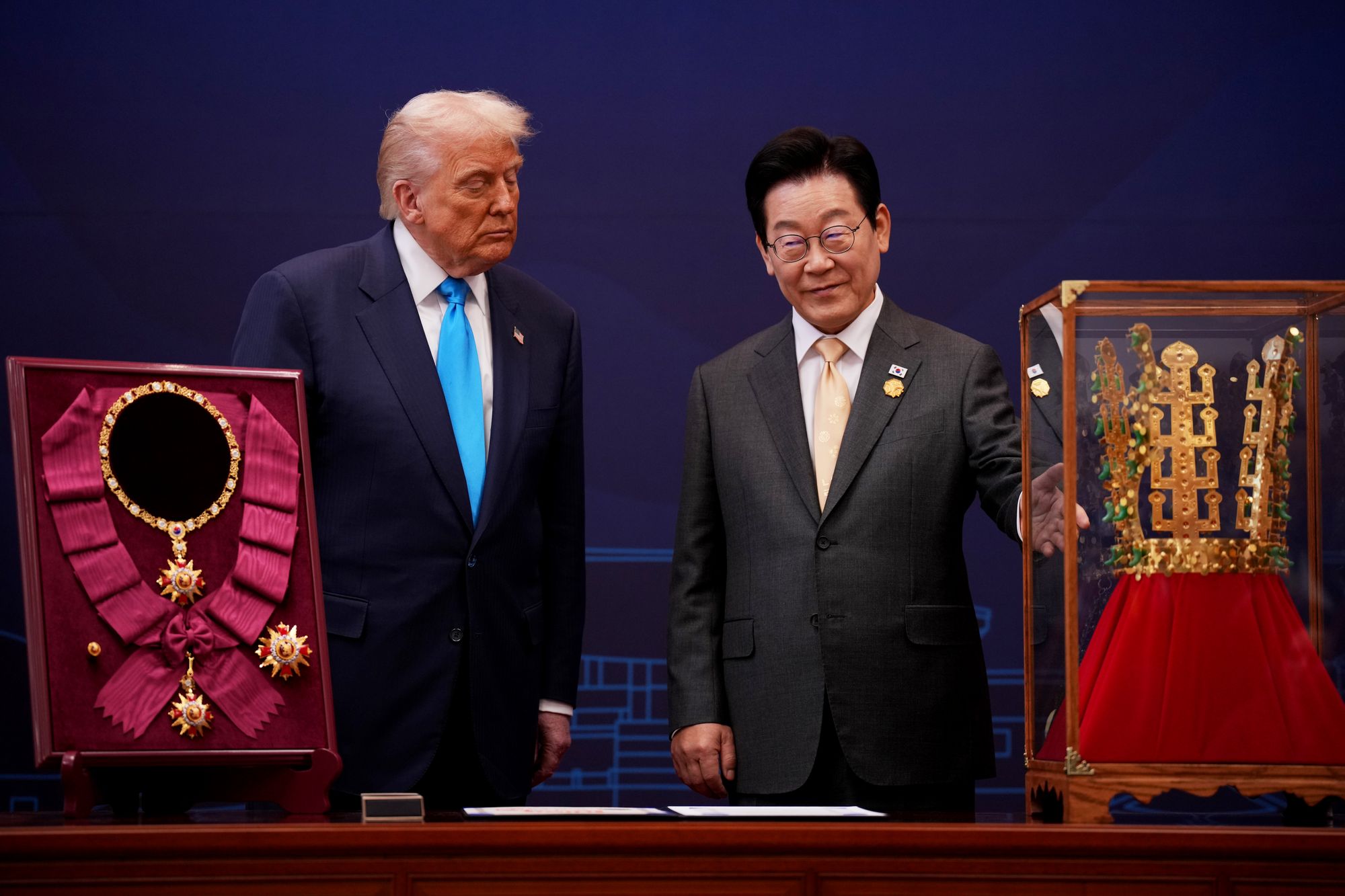 Trump reacts as he is presented with the Grand Order of Mugunghwa and the Silla gold crown by Lee at the Gyeongju National Museum on Wednesday
