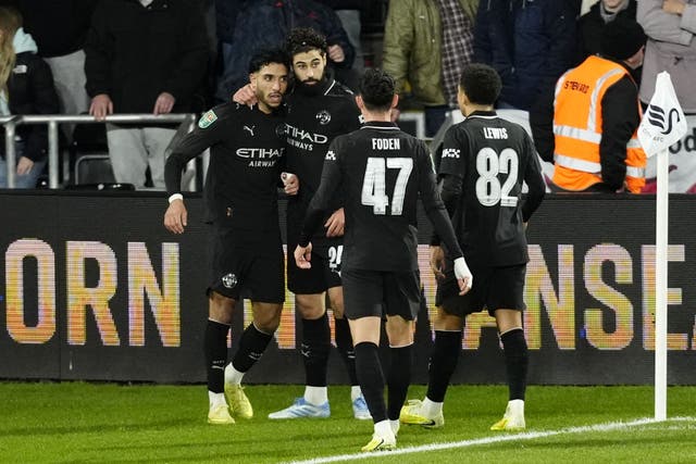 Manchester City’s Omar Marmoush (left) celebrates with team-mates after scoring his side’s second goal at Swansea (Nick Potts/PA)