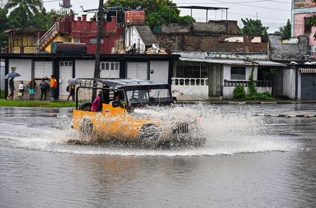 <p>Residents drive a car through flooded areas before Hurricane Melissa hits the city of Santiago de Cuba</p>