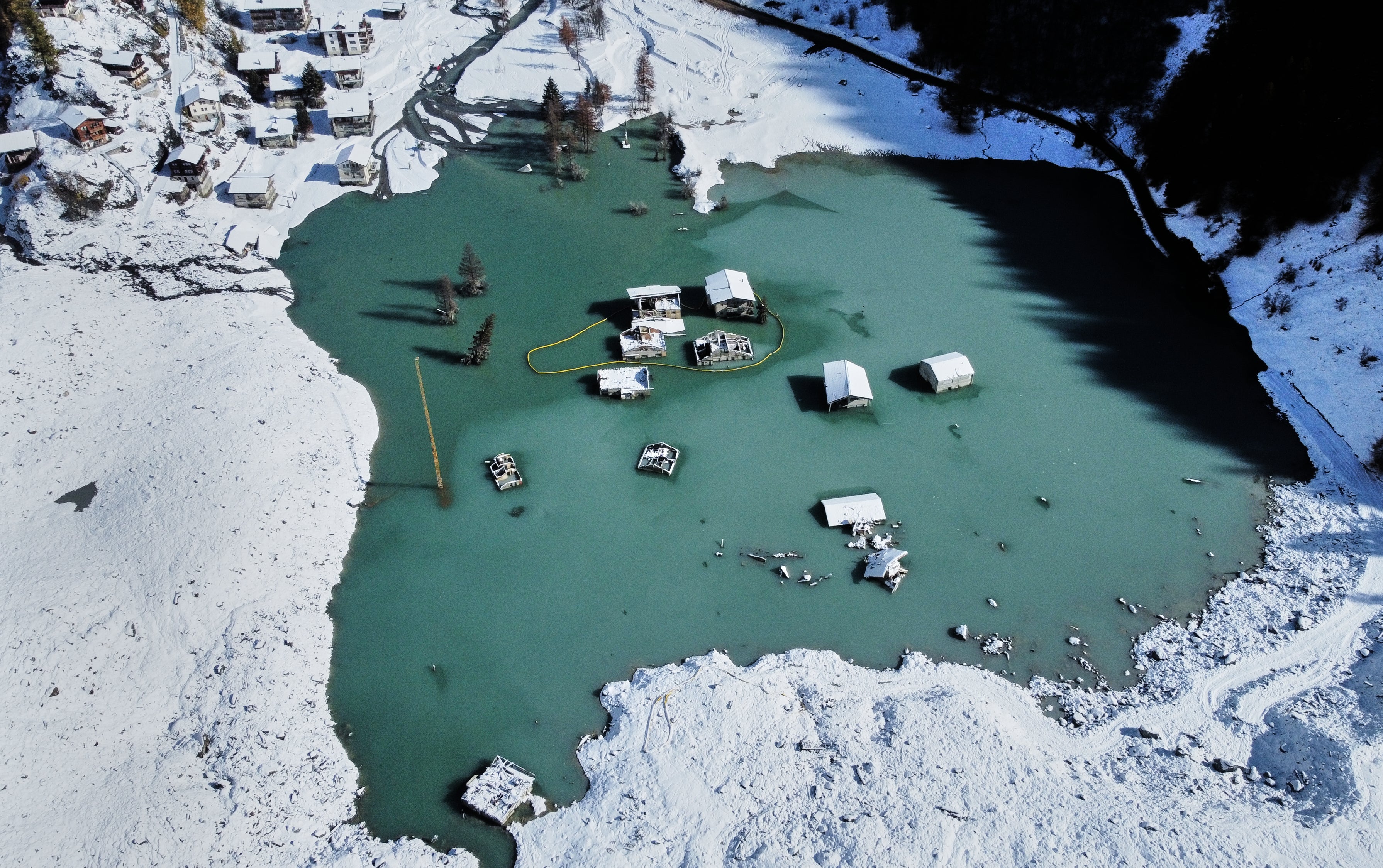 An aerial view shows the partly flooded village of Blatten after snowfalls, five months after a landslide destroyed the village, Blatten, Switzerland, on Tuesday, Oct. 28, 2025. (AP Photo/Michael Probst)