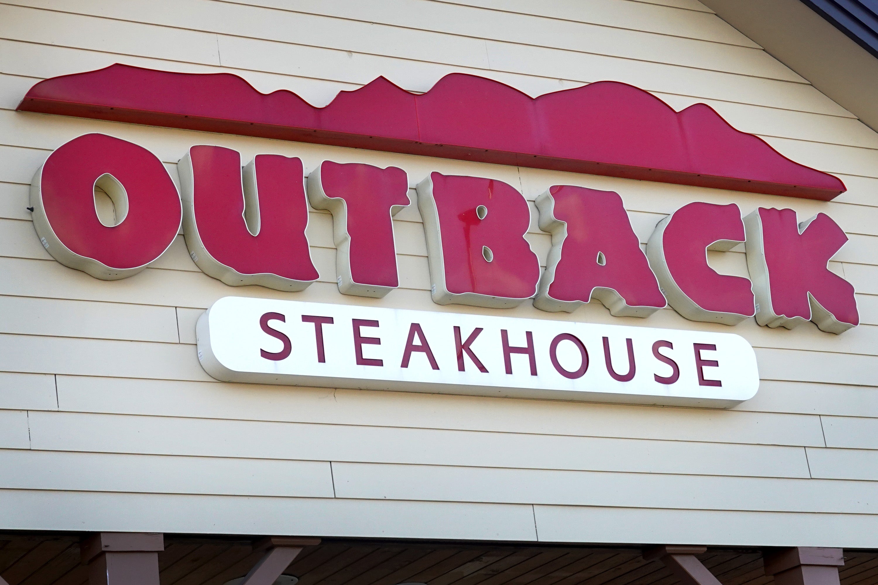SKOKIE, ILLINOIS - NOVEMBER 02: A sign marks the location of an Outback Steakhouse restaurant on November 02, 2021 in Skokie, Illinois. Shares of Bloominâ Brands, the parent company of Outback Steakhouse, closed down 10% today after the company said it expects $170 million in additional costs next year due to inflation