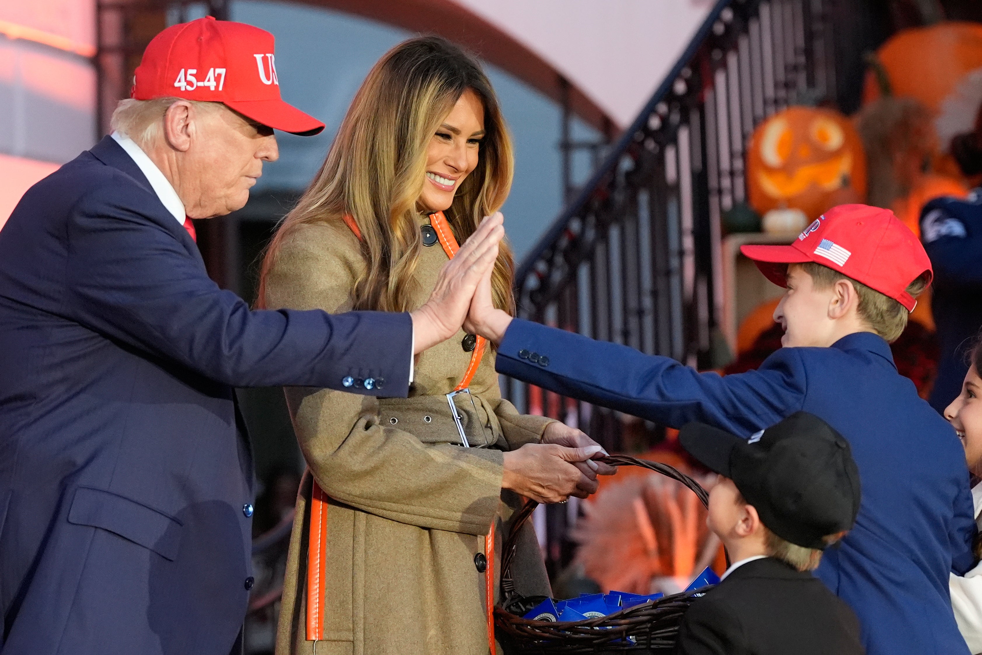President Donald Trump high-fives a trick-or-treater who appears to be dressed up as him at the White House Halloween event