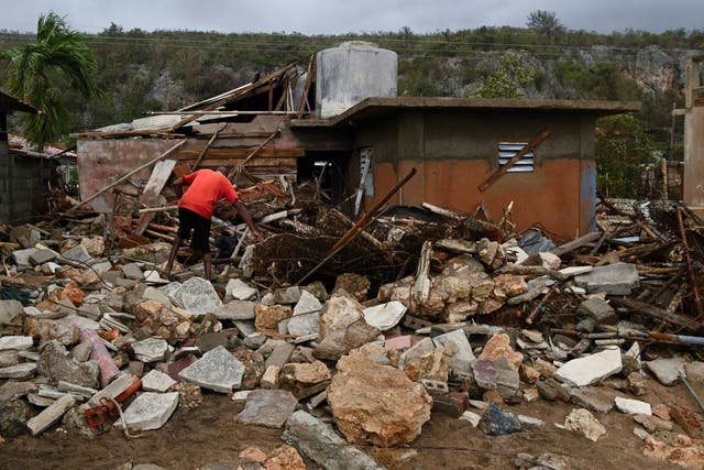 <p>A resident in Santiago, Cuba, removes debris outside his house after Hurricane Melissa</p>