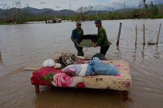 People recover belongings from a home flooded by Hurricane Melissa in Santiago de Cuba, Wednesday