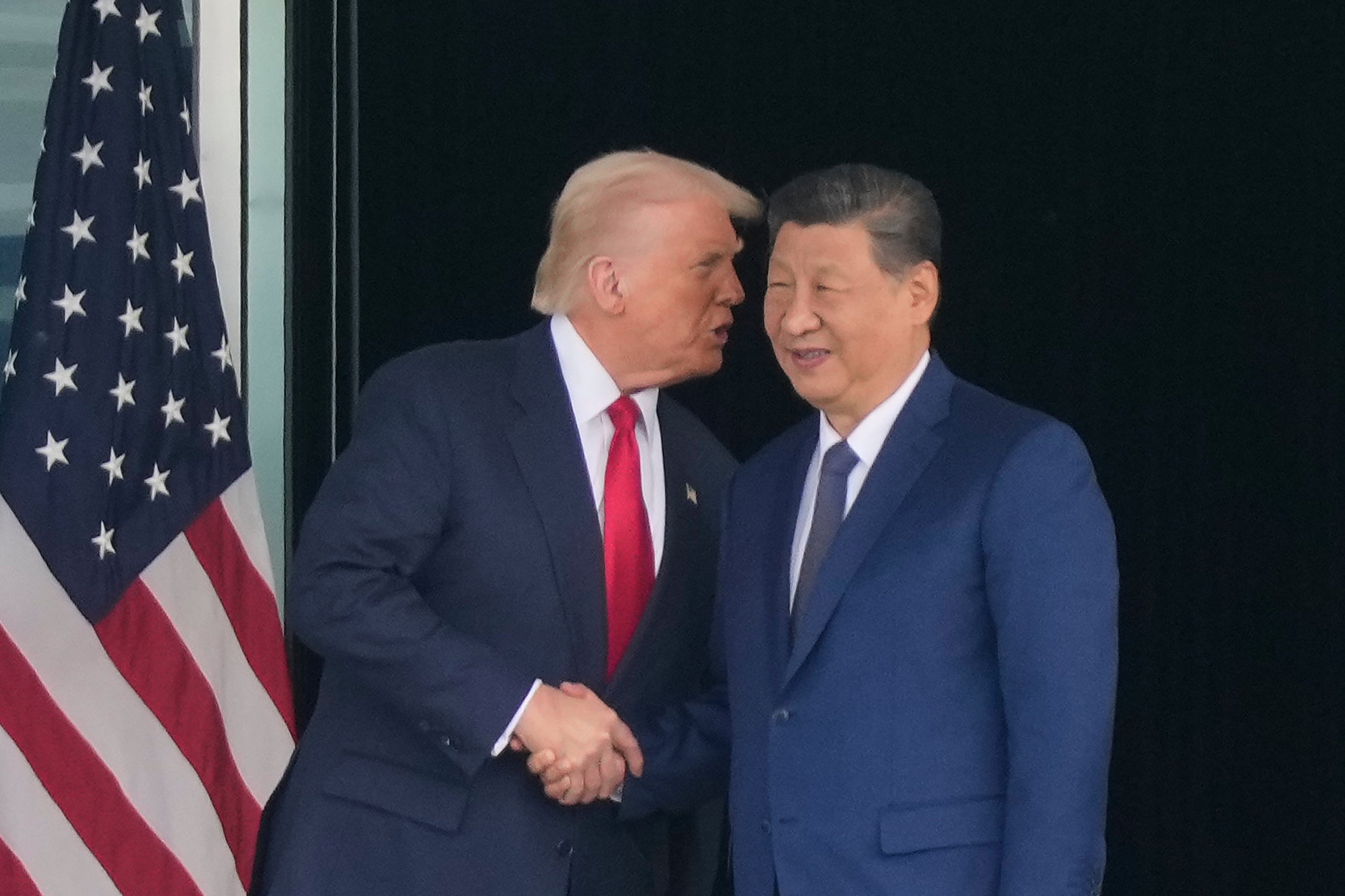 President Donald Trump, left, and Chinese President Xi Jinping, right, shake hands after their US-China summit meeting at Gimhae