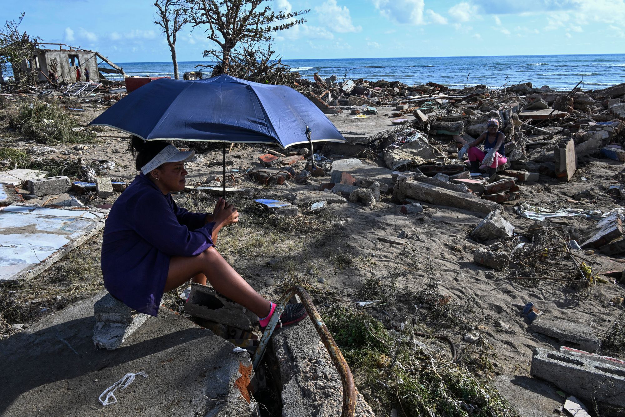 <p>A resident surveys the aftermath of Hurricane Melissa</p>
