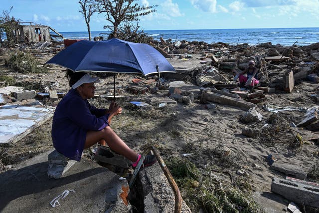 <p>A resident surveys the aftermath of Hurricane Melissa</p>