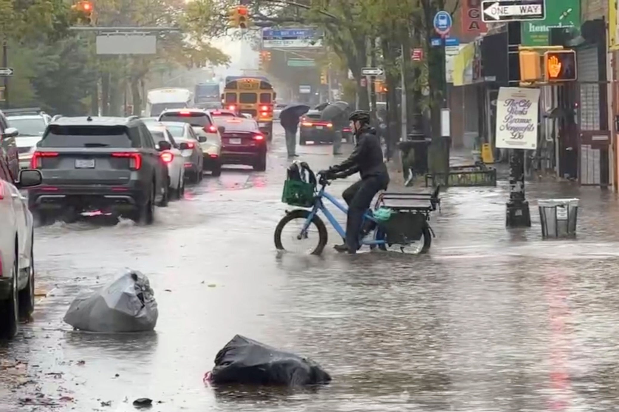 A cyclist rides through floodwaters in New York City on Thursday. At least two New Yorkers died in separate basement flooding incidents