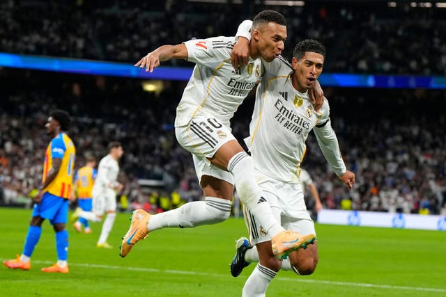 Kylian Mbappe (centre) celebrates with Real Madrid team-mate Jude Bellingham after opening the scoring in the 4-0 win over Valencia (Manu Fernandez/AP)