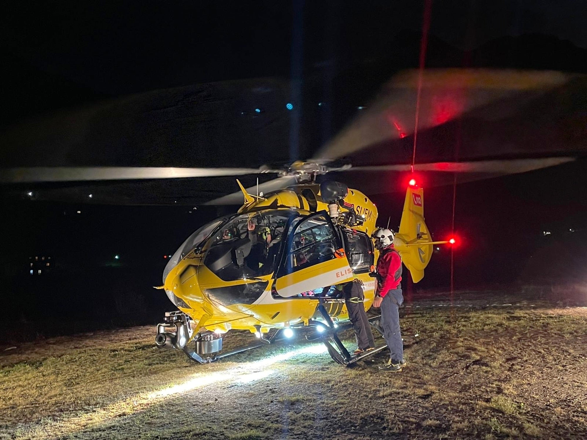 This photo released by the Italian Alpine and Speleological Rescue Corps on Sunday, Nov. 2, 2025, rescuers prepare for rescue operations with a helicopter in search of five mountaineers, all German, who were hit by an avalanche Saturday afternoon