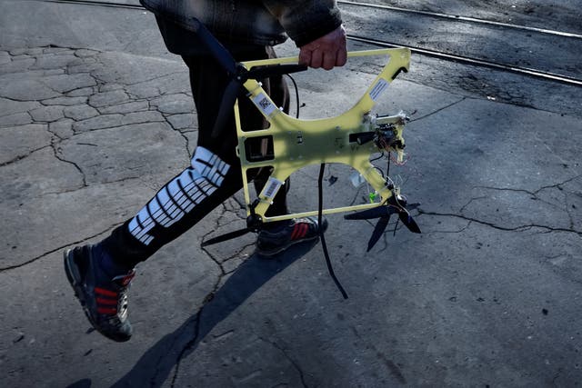 <p>A resident carries a downed Russian FPV drone in the frontline town of Kostiantynivka</p>