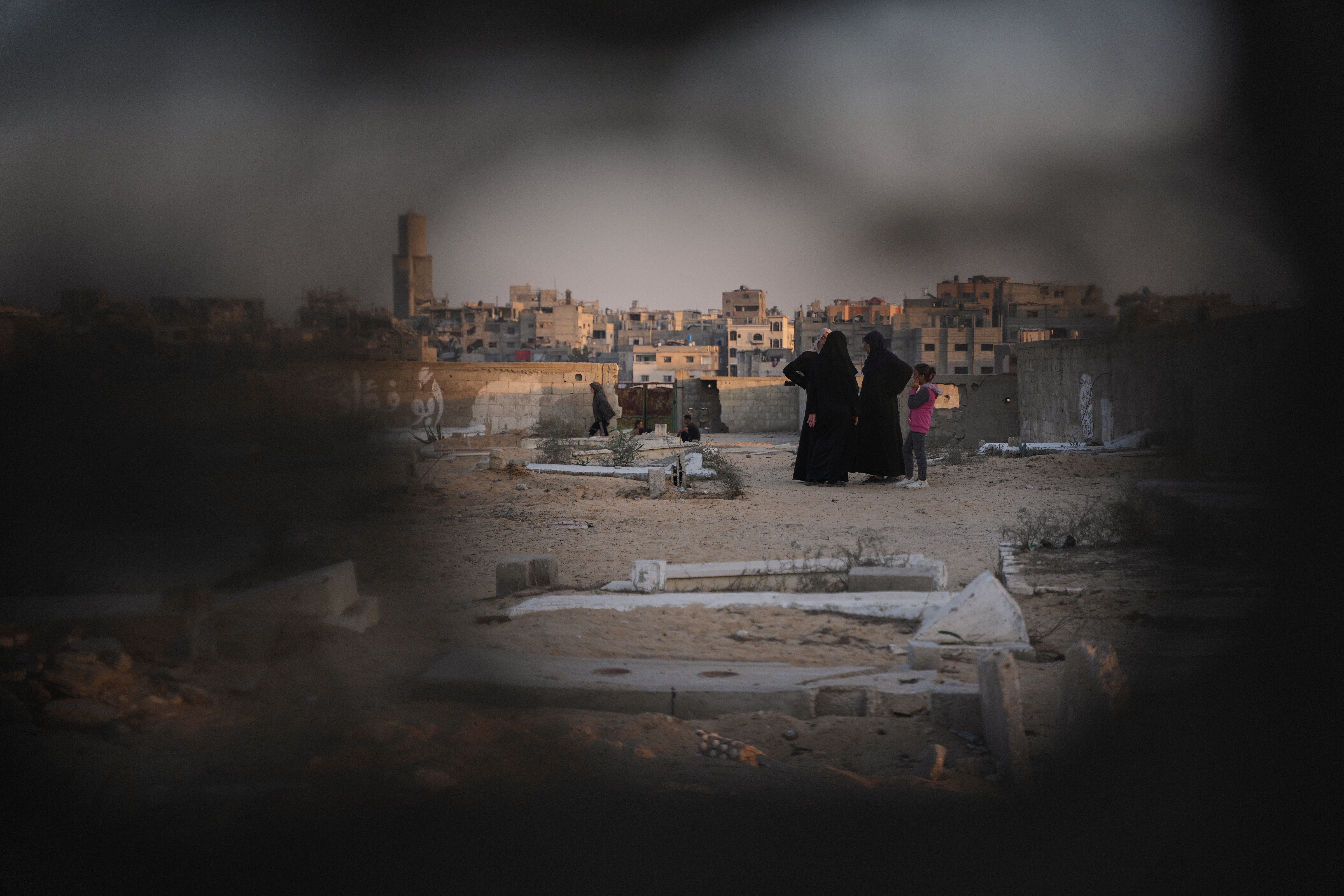 <p>Palestinian women stand at a cemetery in Khan Younis, where a makeshift camp is set up, in southern Gaza on 31 October 2025</p>