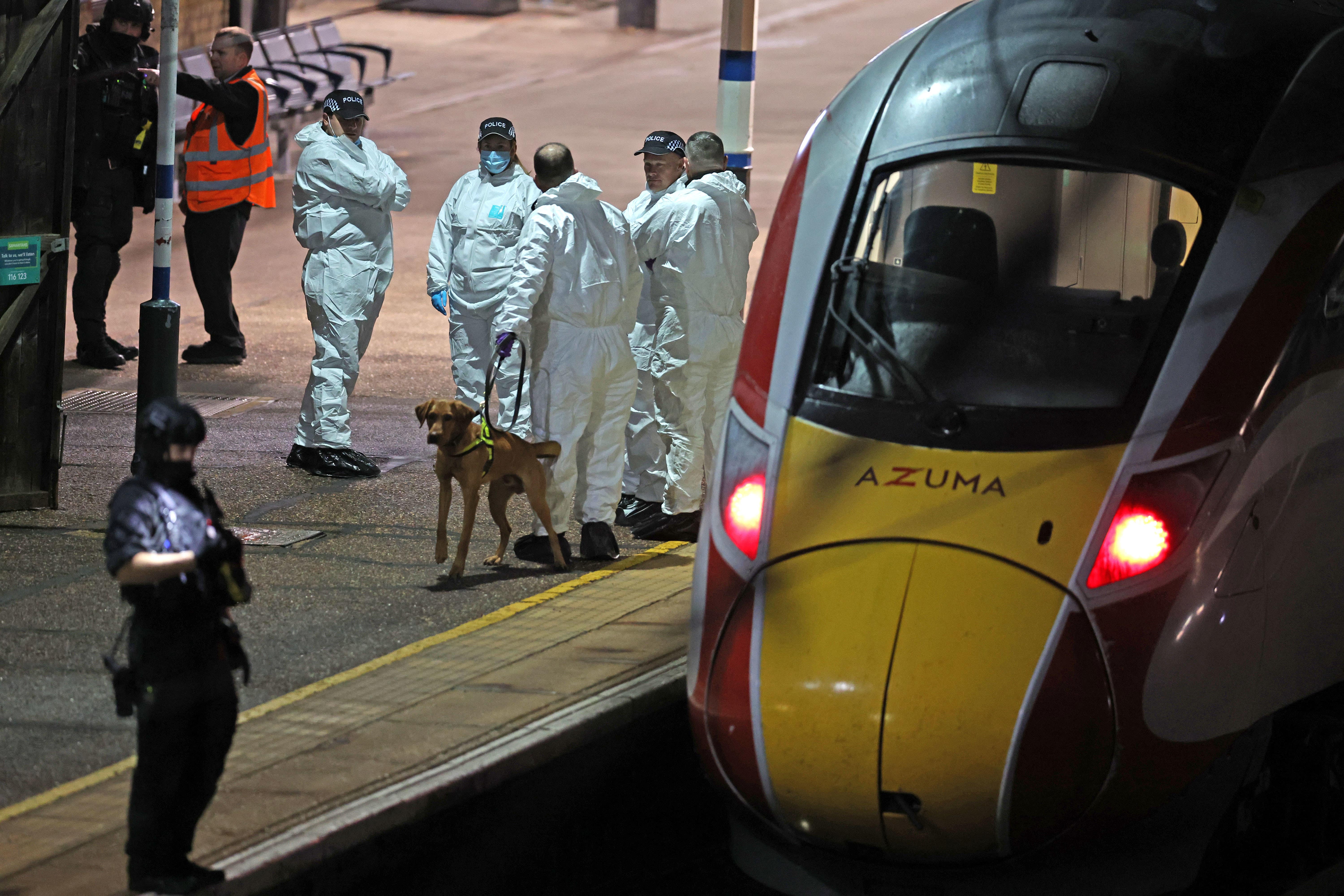 <p>Police on the platform by the train at Huntingdon station in Cambridgeshire after a number of people were stabbed</p>