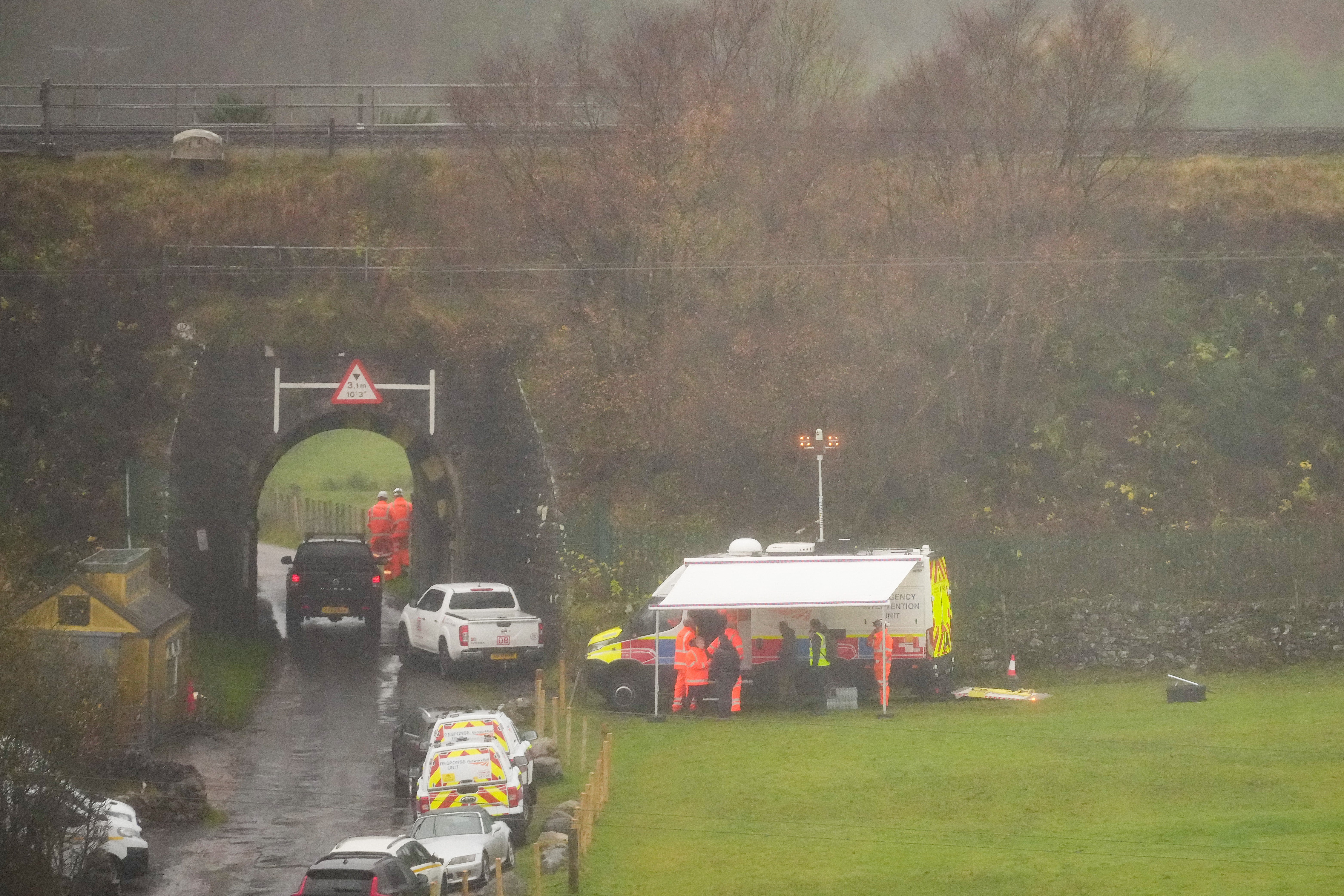 Rail accident investigation vehicles gather near the site of the derailment