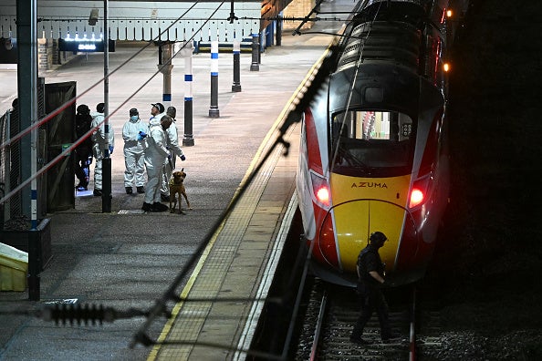 Police officers and a dog handler work on the platform alongside the LNER train at Huntingdon Station