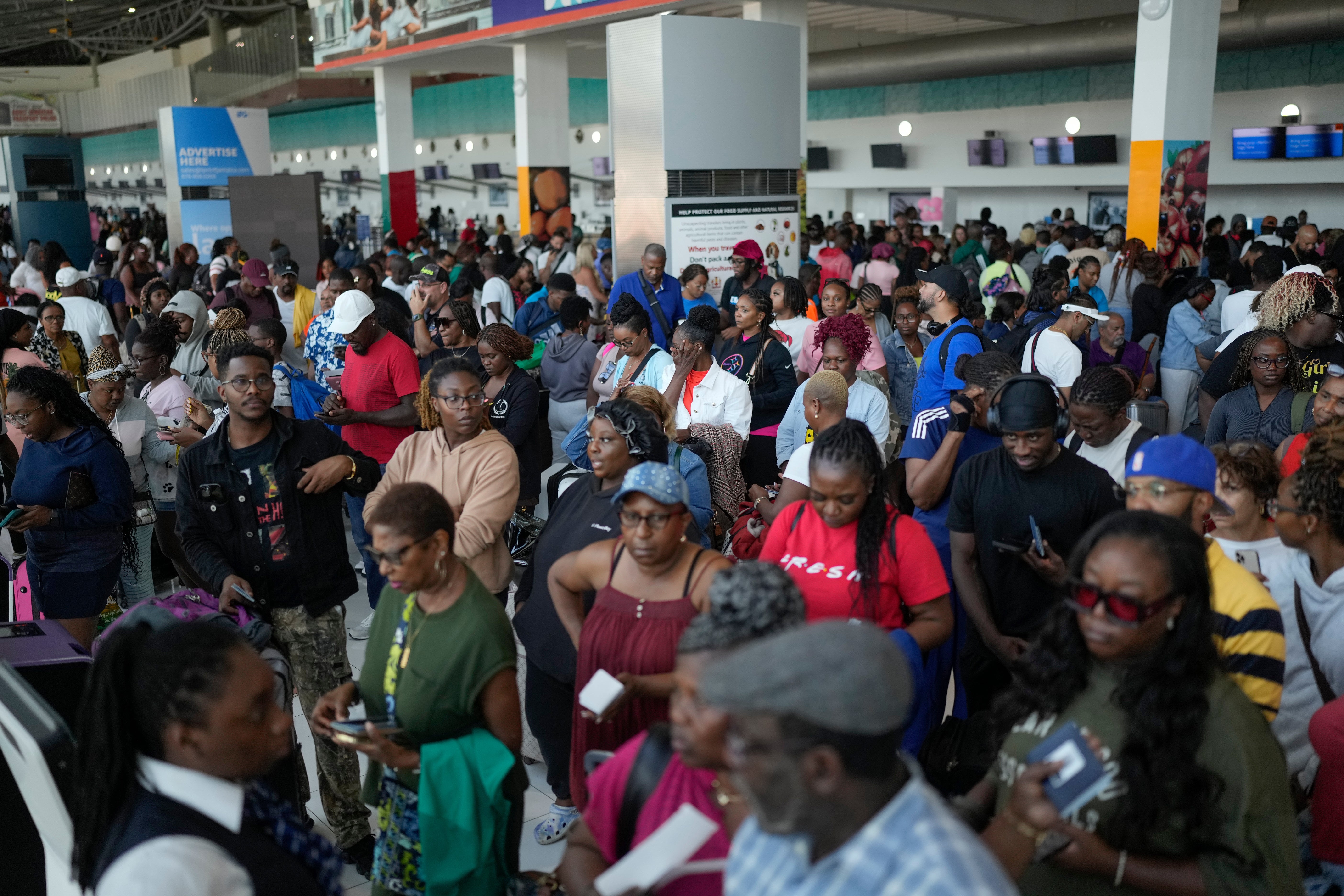 Passengers check in at the Norman Manley International Airport in Kingston, Jamaica, Saturday, Nov. 1, 2025, in the aftermath of Hurricane Melissa. (AP Photo/Matias Delacroix)