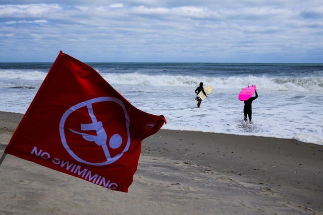 <p>Surfers wade into the water at Rockaway Beach, New York in August. Most of the storm-related impacts to the U.S. this year were rough surf, rip currents and rain</p>