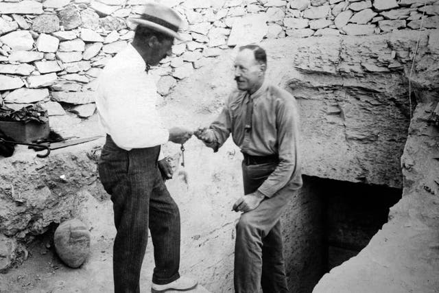 British archaeologist Howard Carter (1874 - 1939, right) hands over the key to the newly discovered tomb of Tutankhamun (designated KV62) in the Valley of the Kings, Egypt, circa 1922