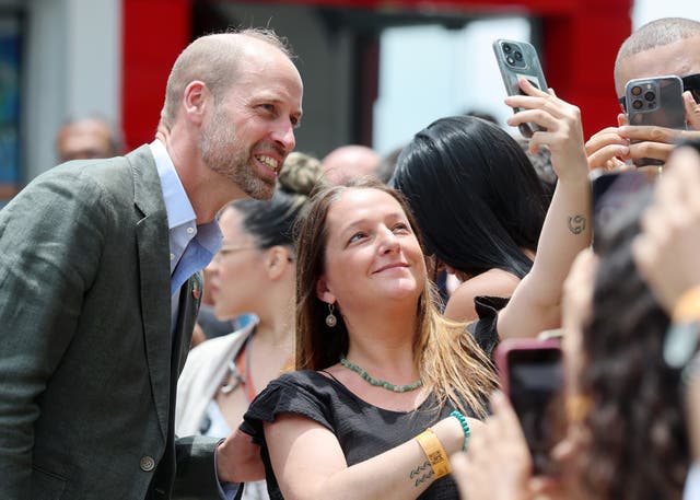 <p>The Prince of Wales poses for pictures with members of the public during a 'Welcome to Rio' event at Sugarloaf Mountain, in Rio de Janeiro</p>