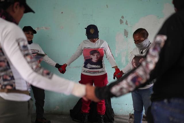 <p>Relatives of missing people, part of a group called the Guerreros Buscadores, pray before inspecting an area where they suspect bodies may be buried, in the Valle de los Olivos neighborhood of Guadalajara, Mexico, Oct. 14, 2025</p>