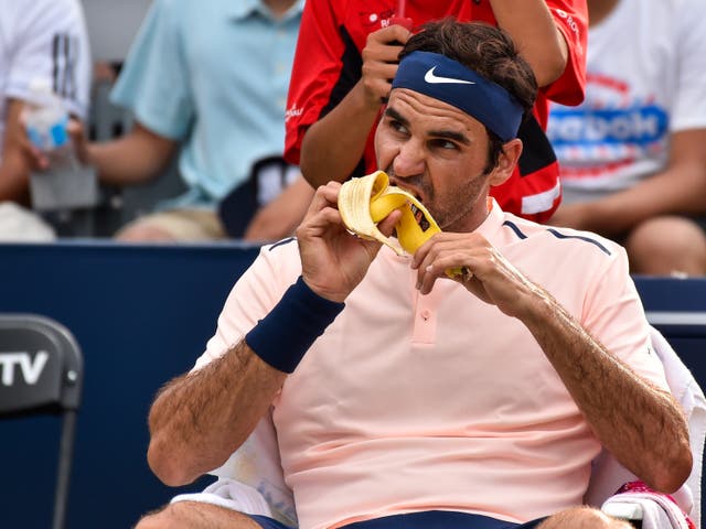<p>Tennis star Roger Federer eats a banana between games at a tournament in Montreal, Canada, in August 2017. Bananas are one of multiple foods that are rich in gut-protecting prebiotic fiber</p>