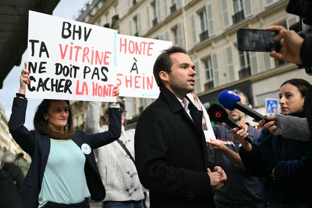 <p>TOPSHOT - Director of Bazar de l'Hotel de Ville (BHV) Karl Cottendin (C) addresses media during a protest of activists belonging to Mouv'Enfants, a movement fighting against all forms of violence against children, in front of the Parisian department store in Paris on November 3, 2025, after Chinese company Shein was selling on its online platform dolls of a likely "child pornography nature". France's Finance minister threatened on November 3, 2025 to ban Shein from the country if the Asian e-commerce giant resumes selling "childlike" sex dolls, just days before it opens its first physical store at BHV in Paris. (Photo by Julie SEBADELHA / AFP) (Photo by JULIE SEBADELHA/AFP via Getty Images)</p>
