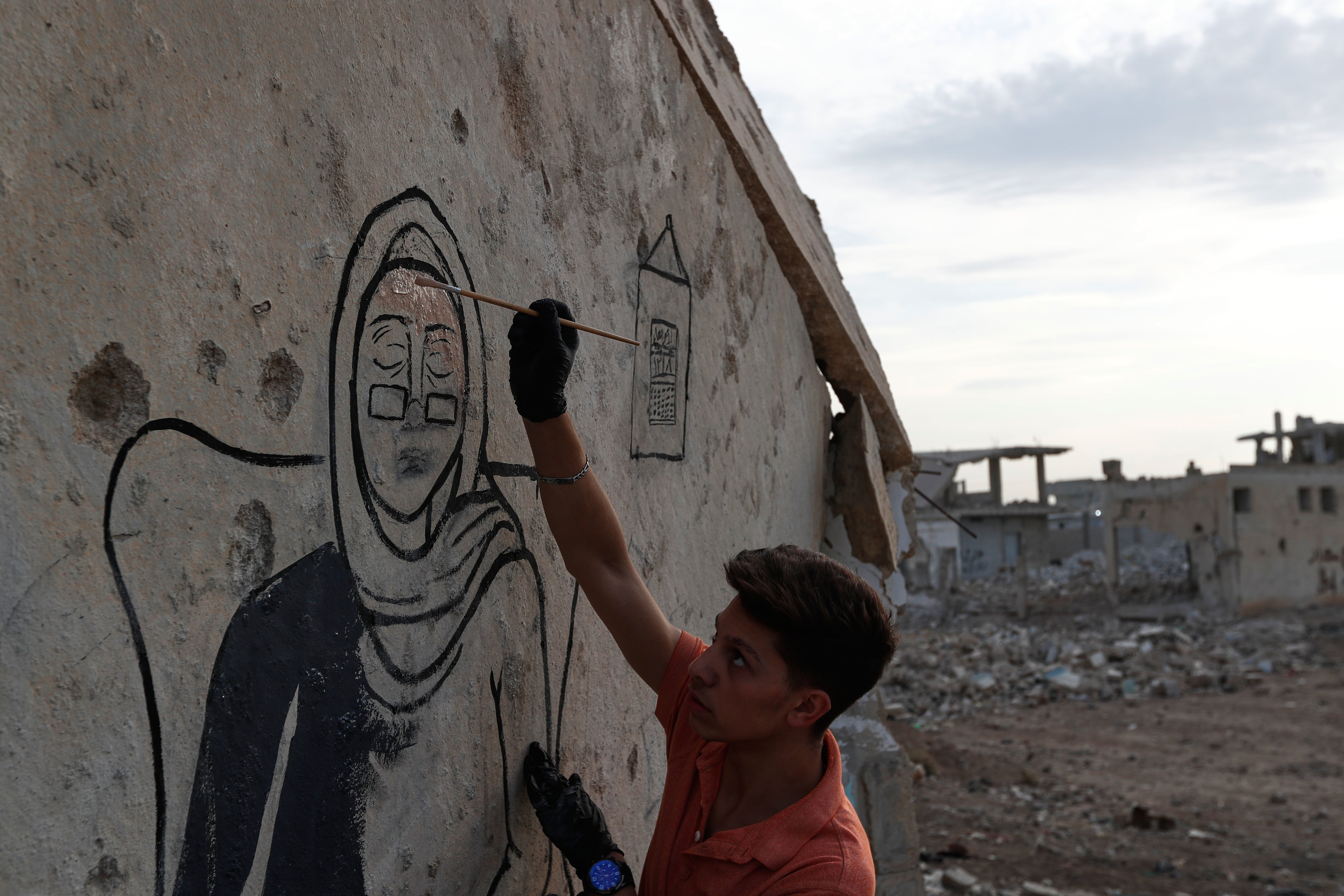 <p>Syrian graffiti artists paint a mural in Daraya, on the outskirts of Damascus, on 3 November 2025</p>