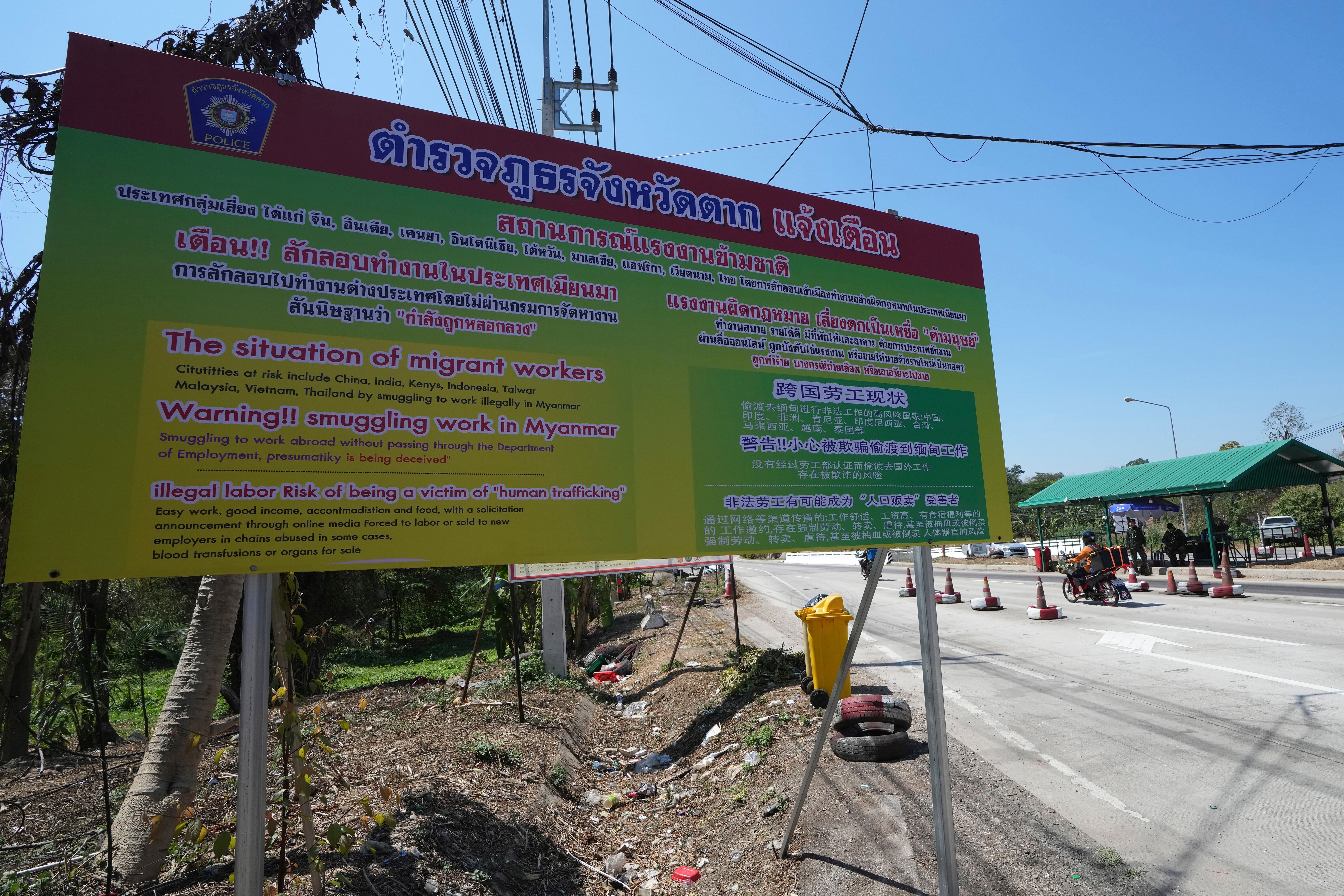 <p>A sign near a military post warns people of the danger of being trafficked and forced to work in scam compounds across the Myanmar border, in Mae Sot, Thailand (file photo)</p>