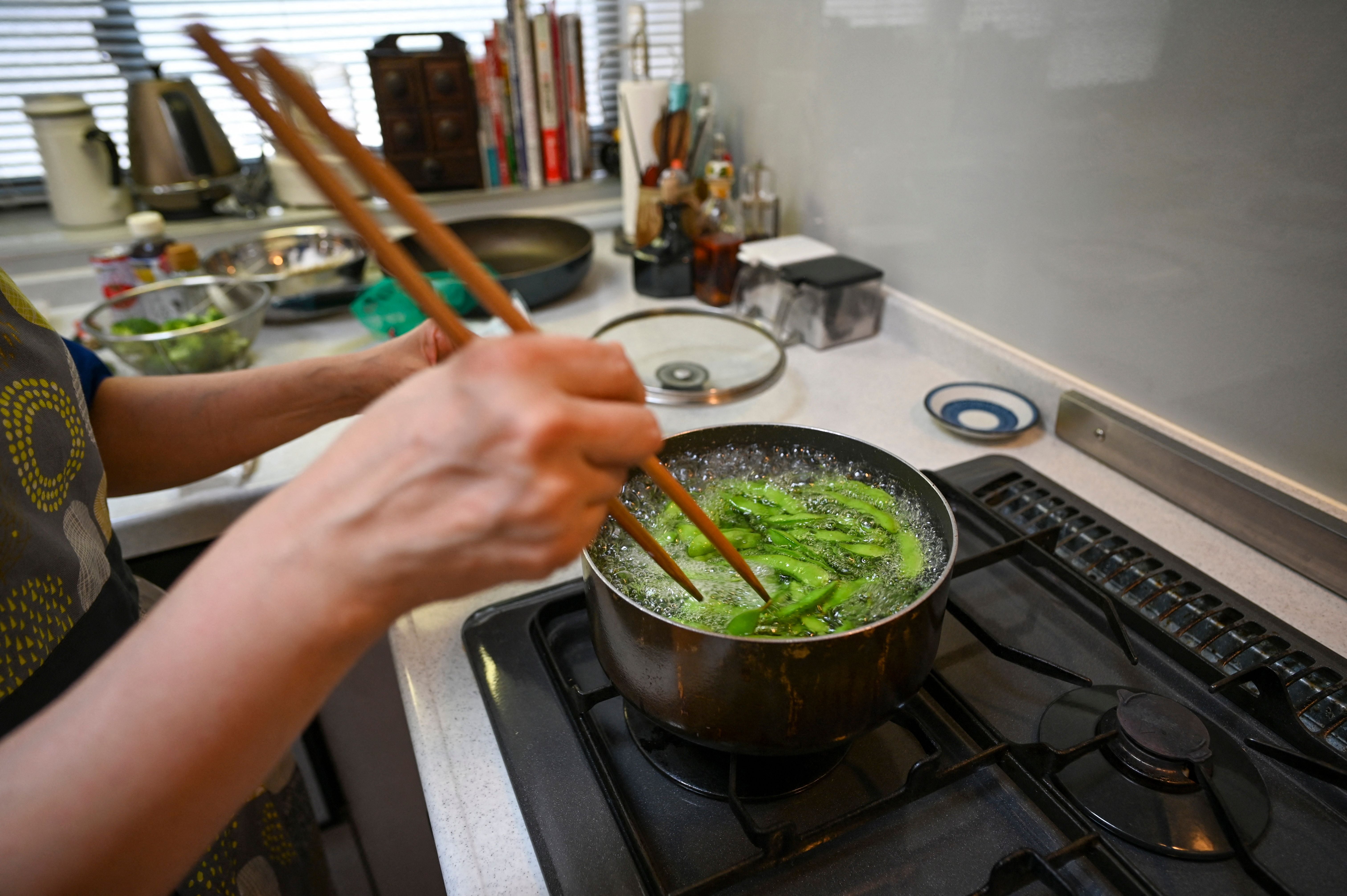 A woman boils edamame soybeans in Tokyo, Japan. Soybeans and other legumes are a major feature of the diet, providing ample plant protein
