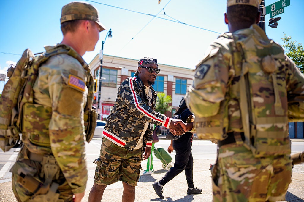 Advisory Neighborhood Commission commissioner Paul Spiles shakes a Guardsman's hand, one of a few local officials who've taken advantage of the Guard deployment to direct local beautification efforts