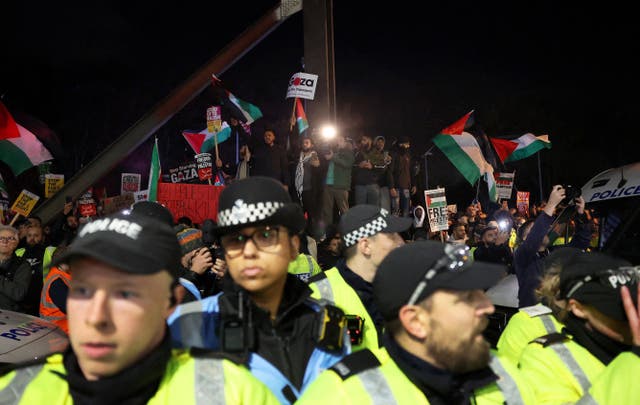 <p>Police officers and protesters outside the stadium before the match</p>