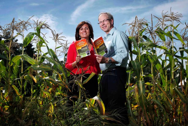 <p>Farmers' Almanac editor Sandi Duncan and publisher Peter Geiger pose in a corn field with the 2012 edition of the almanac in Auburn, Maine</p>