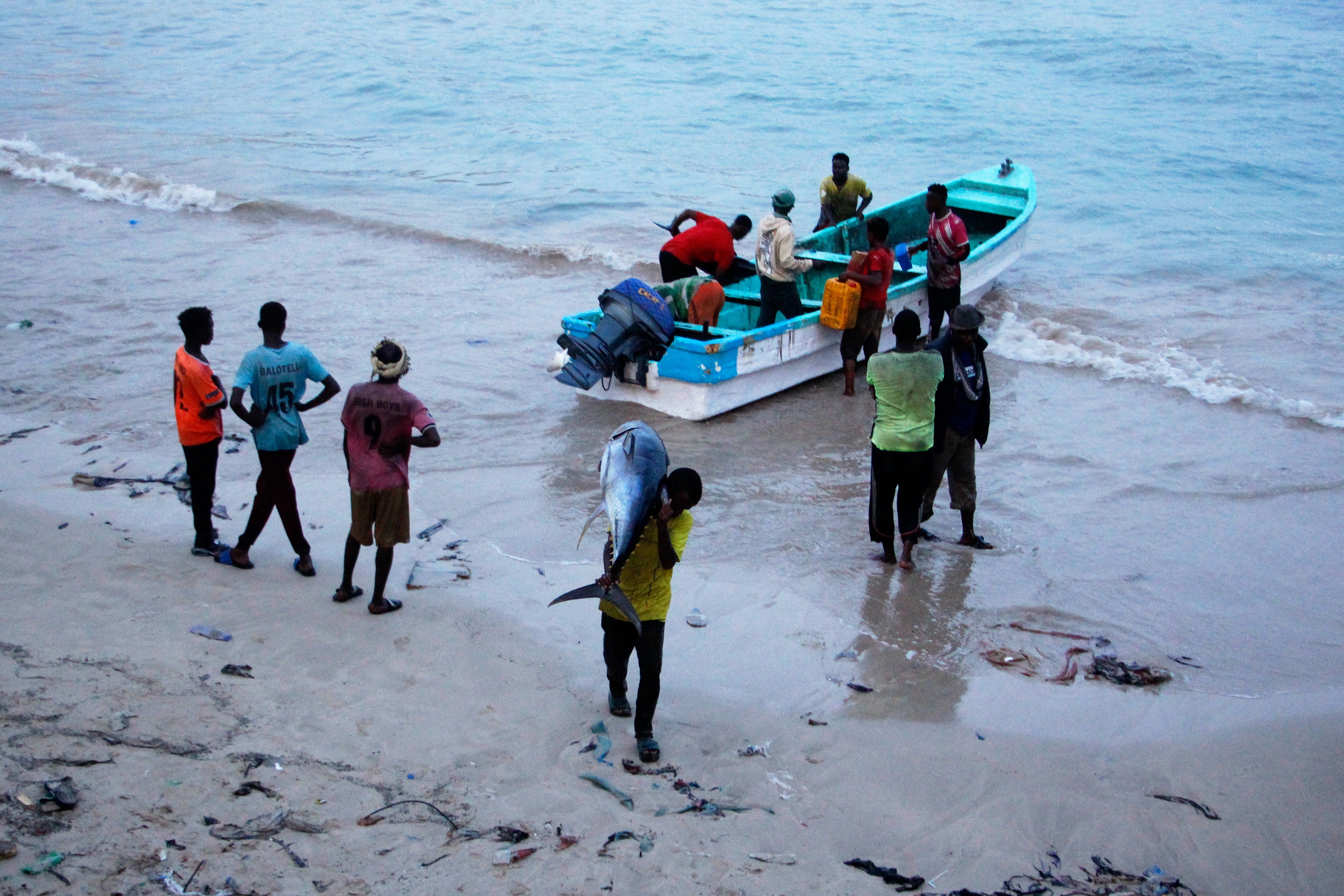 A fisherman carries a tuna fish to the market in Mogadishu, Somalia Thursday, Nov. 6, 2025. (AP Photo/Farah Abdi Warsameh)