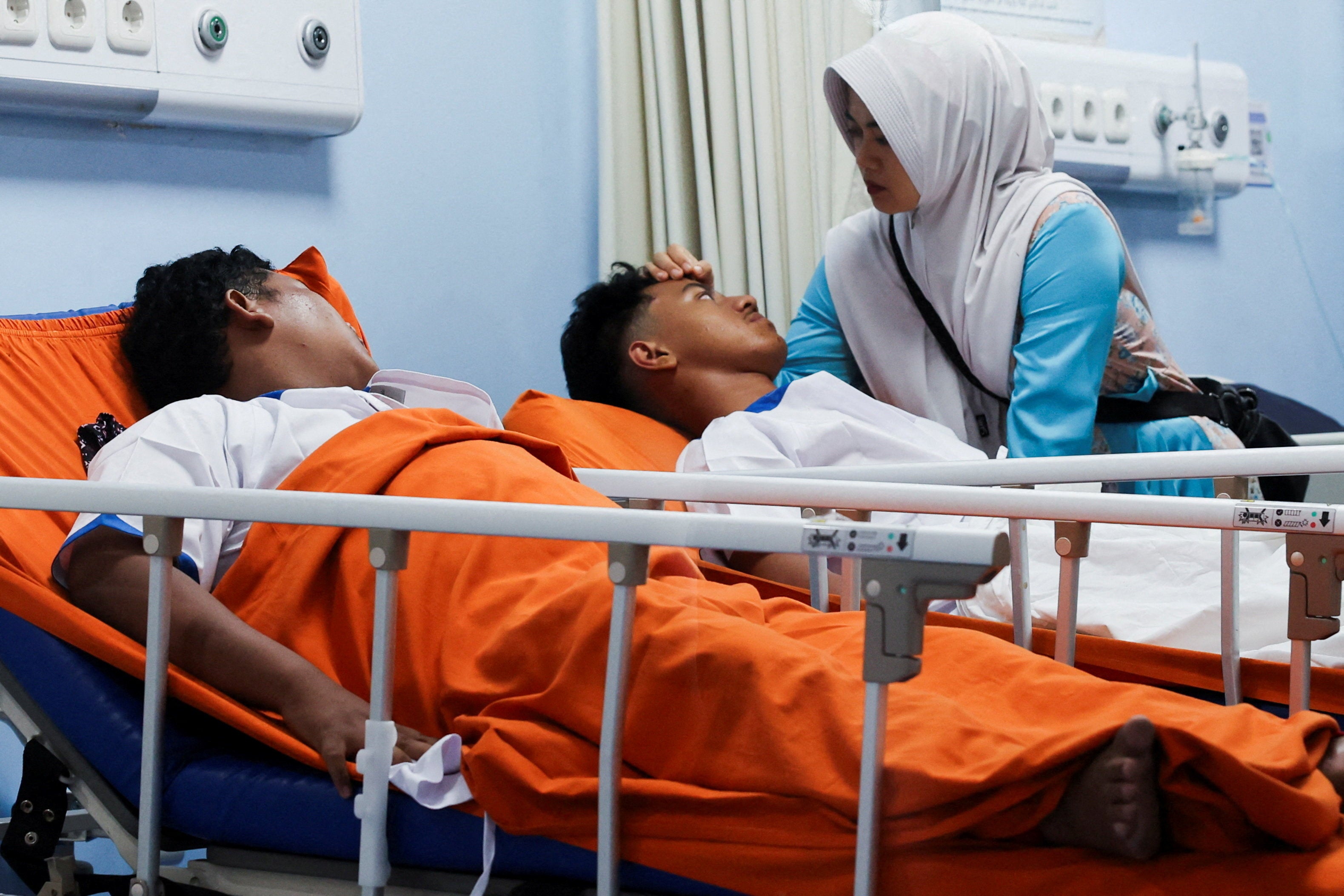 A relative gestures while injured students lie at Jakarta Islamic hospital after an explosion occurred during Friday prayers at a mosque inside a school complex in Jakarta, Indonesia, November 7, 2025. REUTERS/Ajeng Dinar Ulfiana TPX IMAGES OF THE DAY