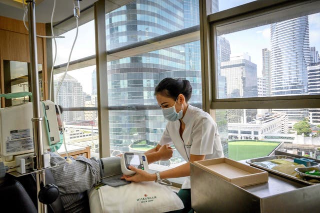 <p>Health care worker takes blood pressure of patient</p>