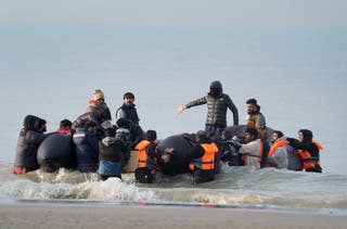 People thought to be immigrants try to board a small boat in Gravelines, France (Gareth Fuller/PA)