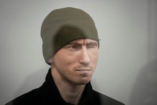 Russian soldier Dmitry Kurashov accused of committing a war crime by executing a Ukrainian serviceman who had surrendered during combat, sits inside a cage during a court hearing expected to deliver a verdict in Zaporizhzhia