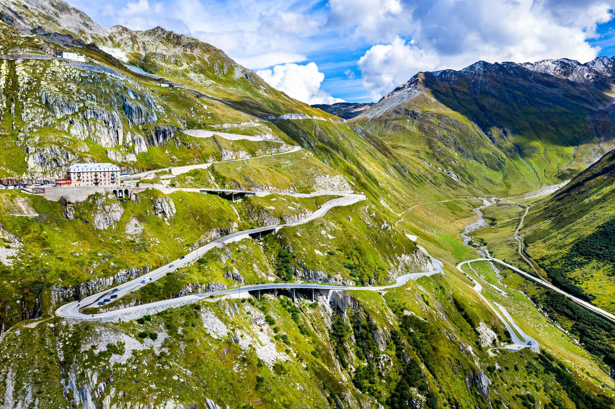 The Furka Pass, immortalized by Bond movie Goldfinger, offers stunning views, with dramatic drops below and towering, craggy peaks all around