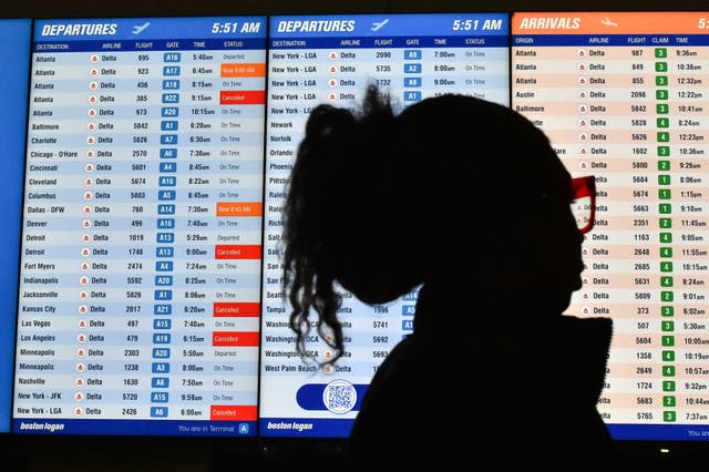 <p>A passenger looks at canceled and delayed flights at Boston Logan International Airport</p>