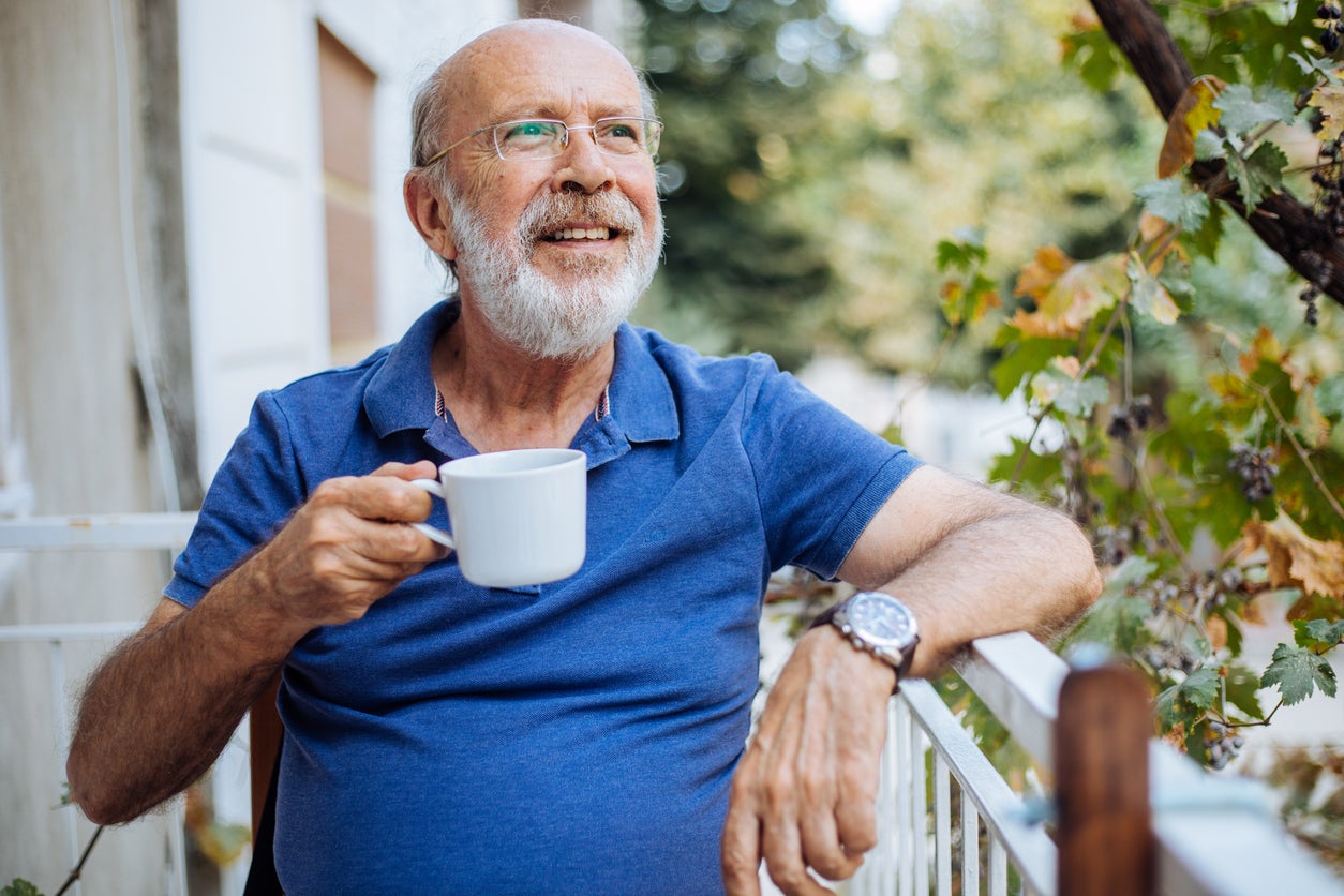 Smiling mature man enjoying in morning coffee on a terrace