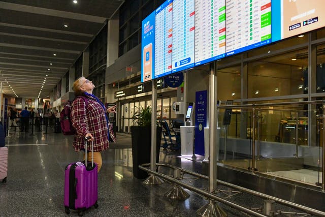 <p>A person checks the status of their flight on a departures board at Boston Logan International Airport in Boston, Massachusetts on November 10, 2025</p>