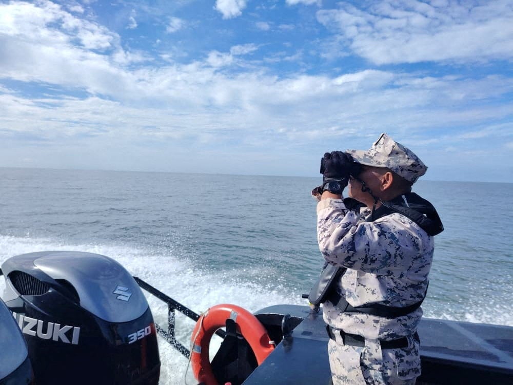 A member of the Malaysian Maritime Enforcement Agency searches for survivors