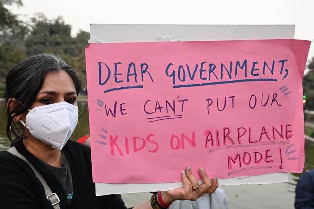 <p>A woman wearing a mask holds a poster during a protest demanding the government take action to reduce air pollution in New Delhi on November 9, 2025. (Photo by Sajjad HUSSAIN / AFP) (Photo by SAJJAD HUSSAIN/AFP via Getty Images)</p>