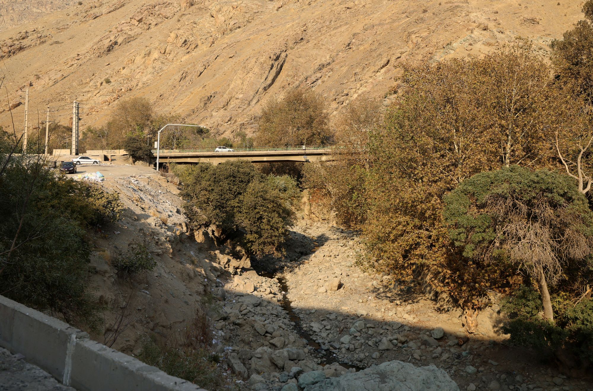 <p>A car drives over a bridge crossing the dried-up Kan River, west of Tehran, on 9 November</p>