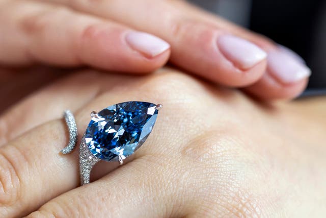 <p>A Christie's employee displays the Mellon Blue diamond ring</p>