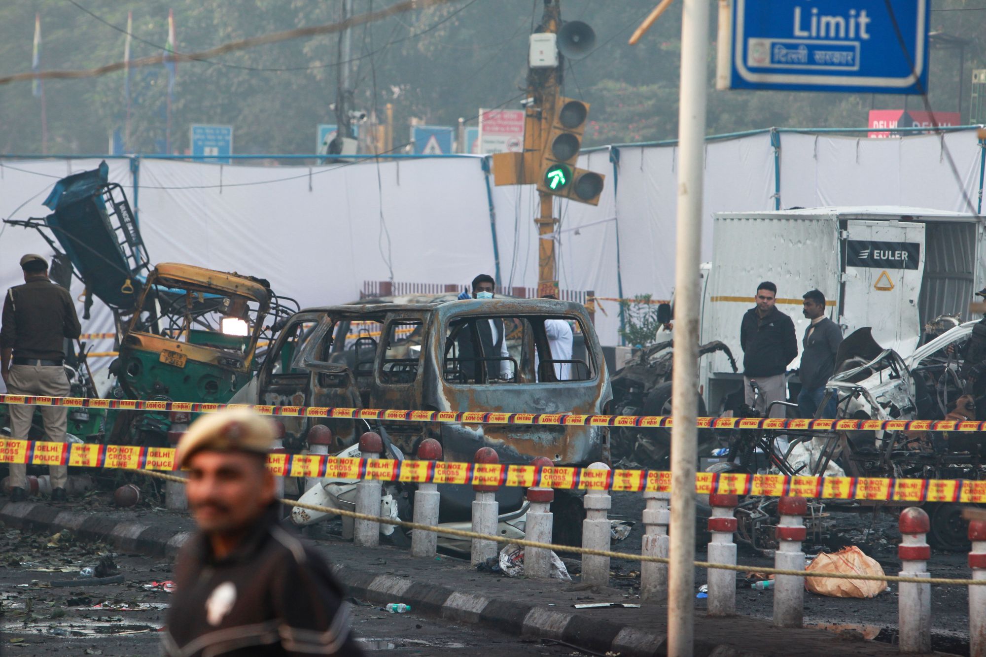 A policeman stands guard as investigators examine the site of the car explosion in Delhi, India, on 11 November 2025