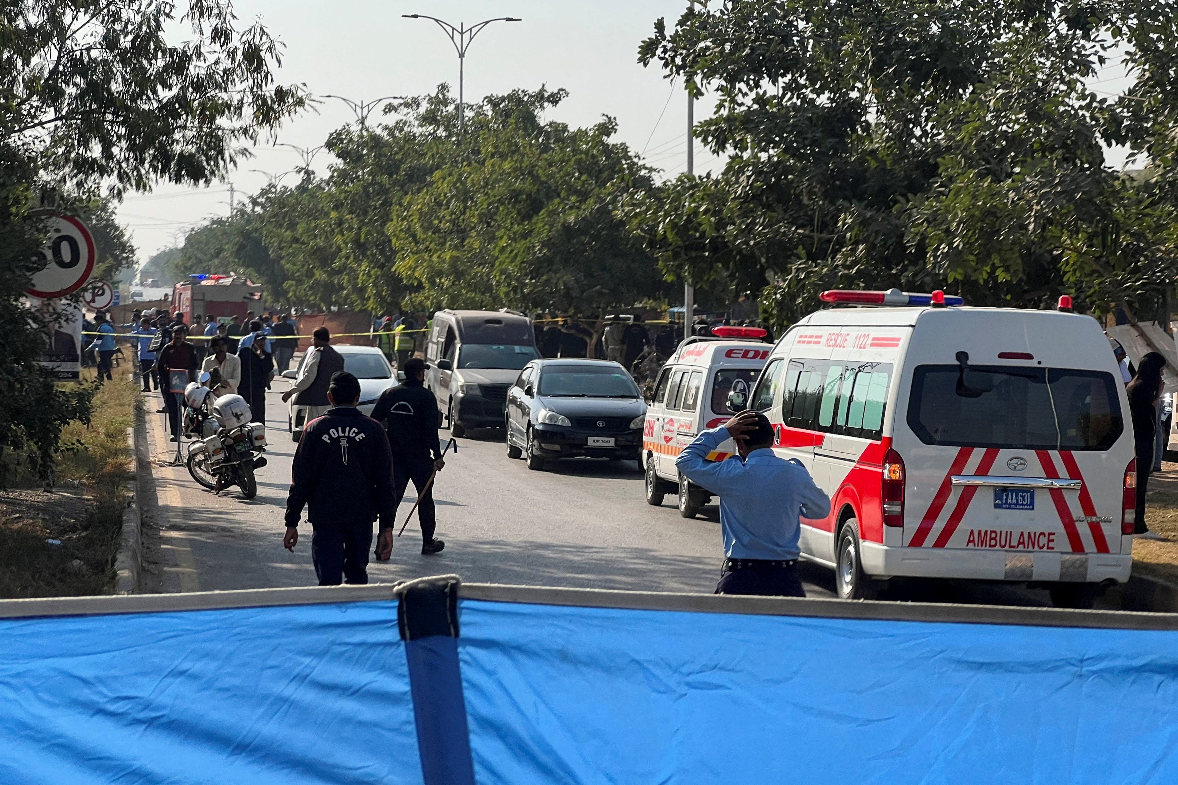 <p>Police officers and ambulances on the road, which is cordoned off, after a blast outside a court building in Islamabad, Pakistan, 11 November 2025</p>