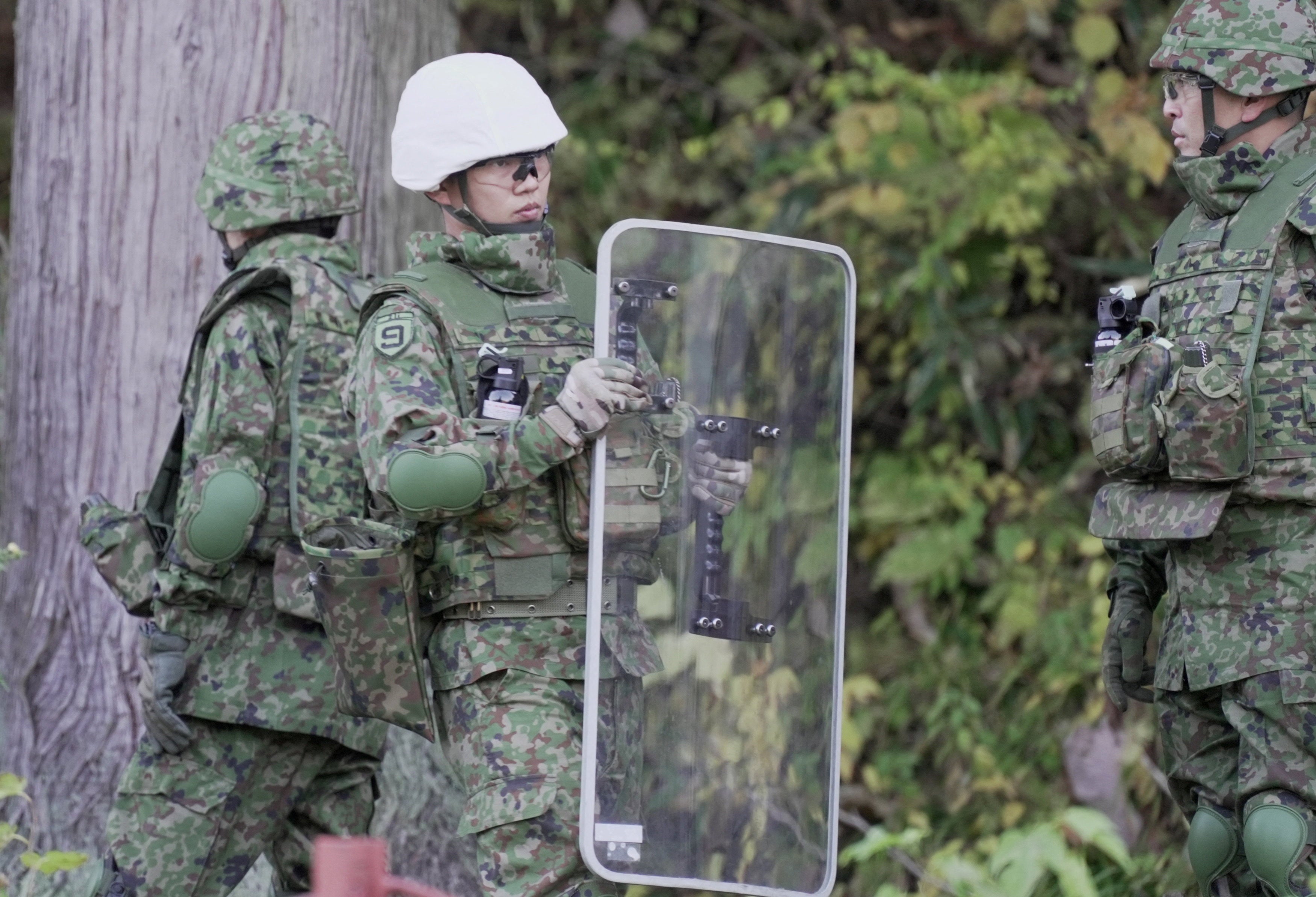 Um membro das Forças de Autodefesa do Japão (JSDF) segura um escudo durante um treino de montagem de armadilhas para ursos em Kazuno, província de Akita, Japão, 5 de novembro de 2025.
