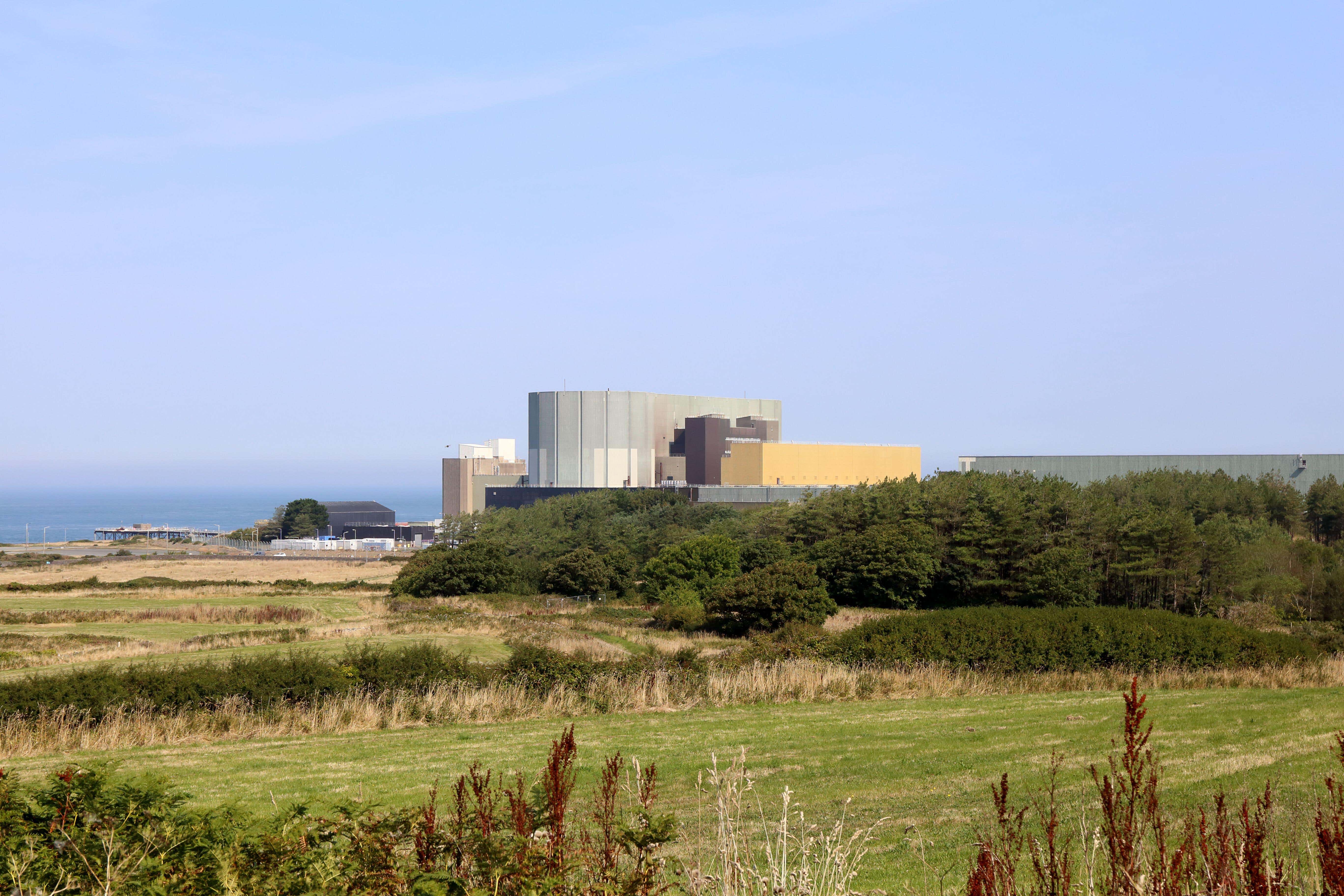 A view across fields of the old nuclear power plant at Wylfa, Anglesey, in 2022 (Alamy/PA)
