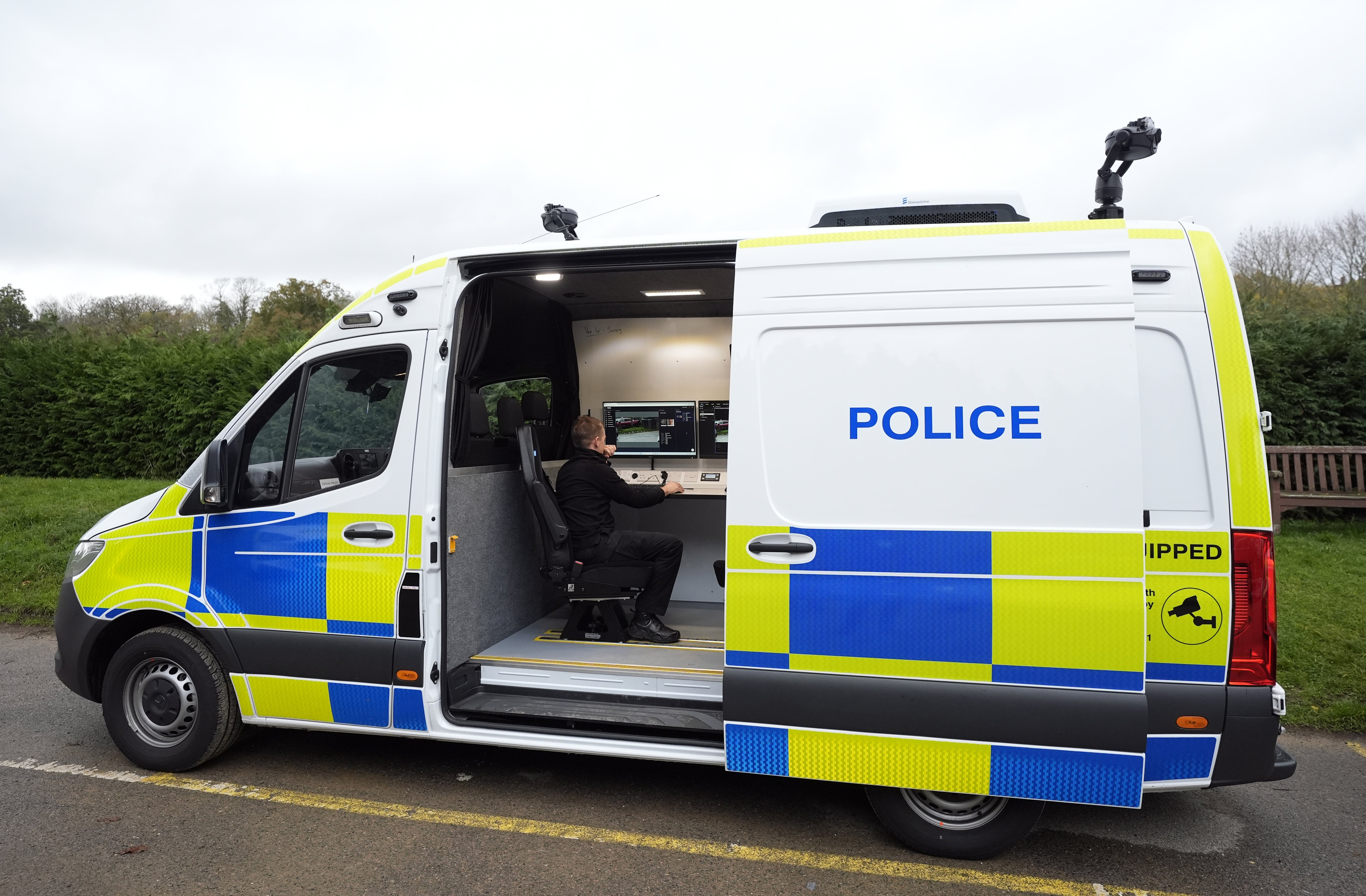 <p>A police officer views a camera feed from inside a live facial recognition van</p>